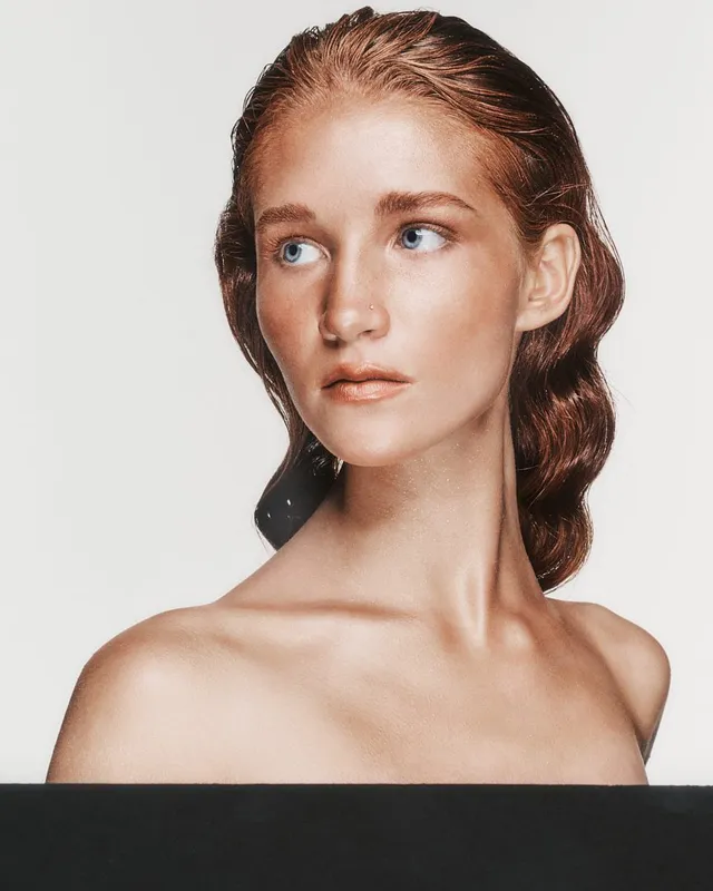 Portret modelki z upiętymi rudymi włosami na białym tle
